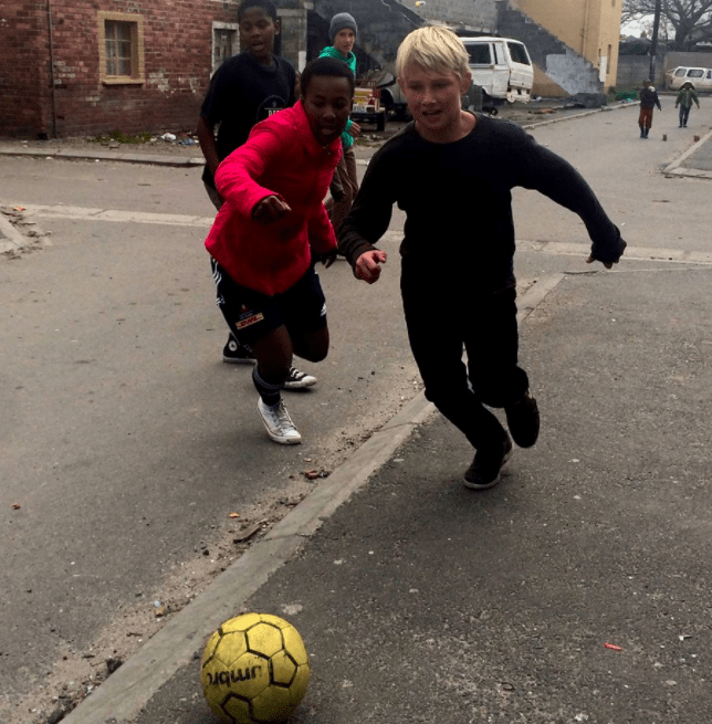 playing soccer with kids in Africa township