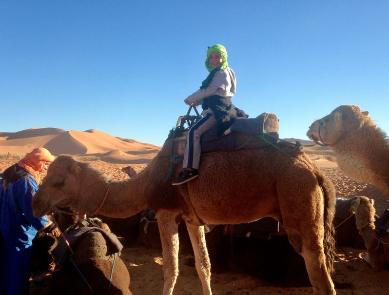 Kids riding camels in the Sahara desert, Morocco
