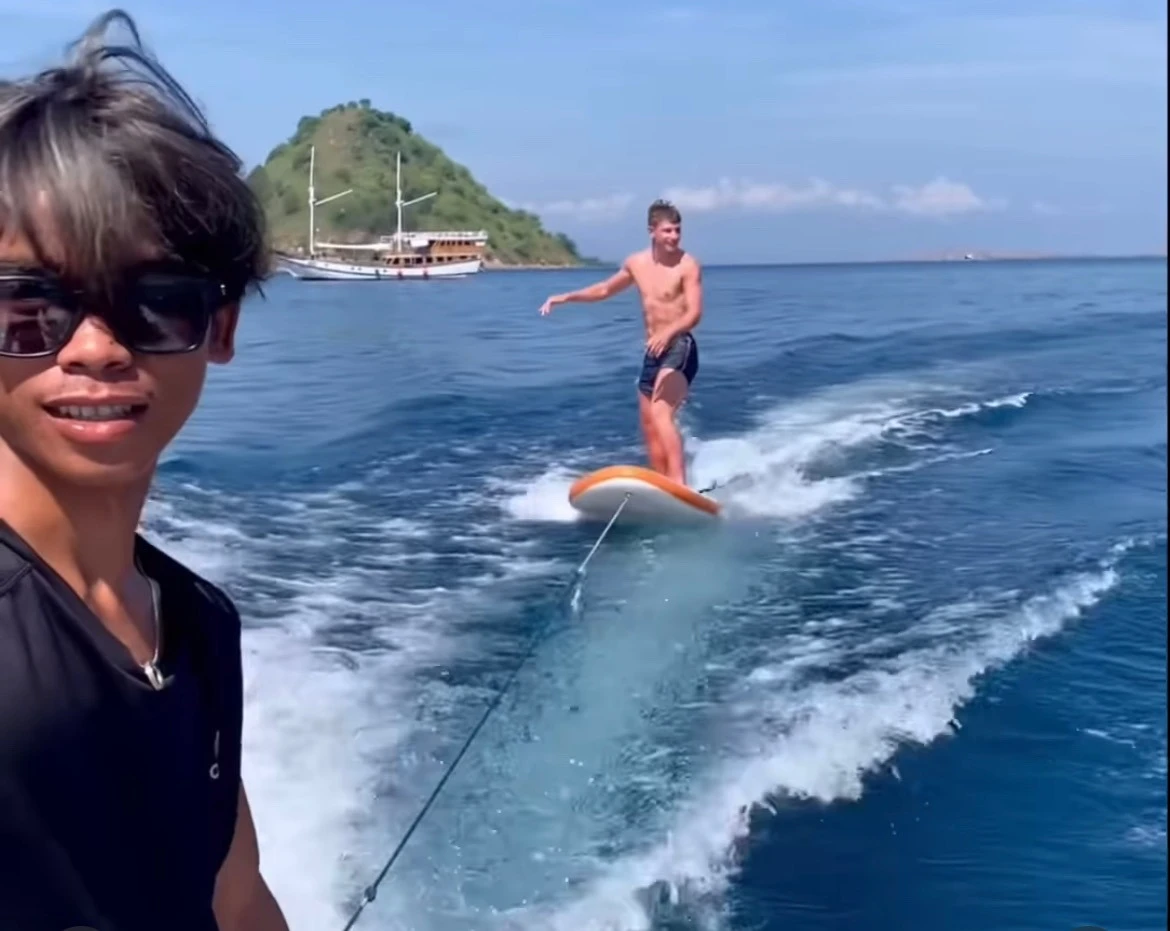 Kids will be kids. Wake surfing on a paddle board, around Kelor island